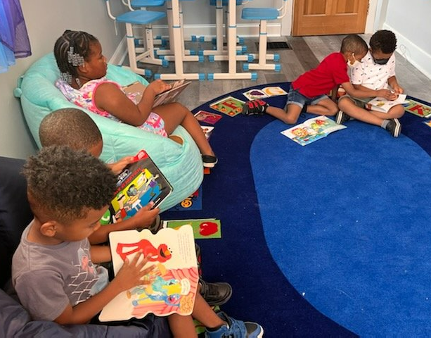 A group of children are sitting on the floor reading books