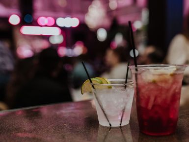 Two drinks are sitting on a bar counter.