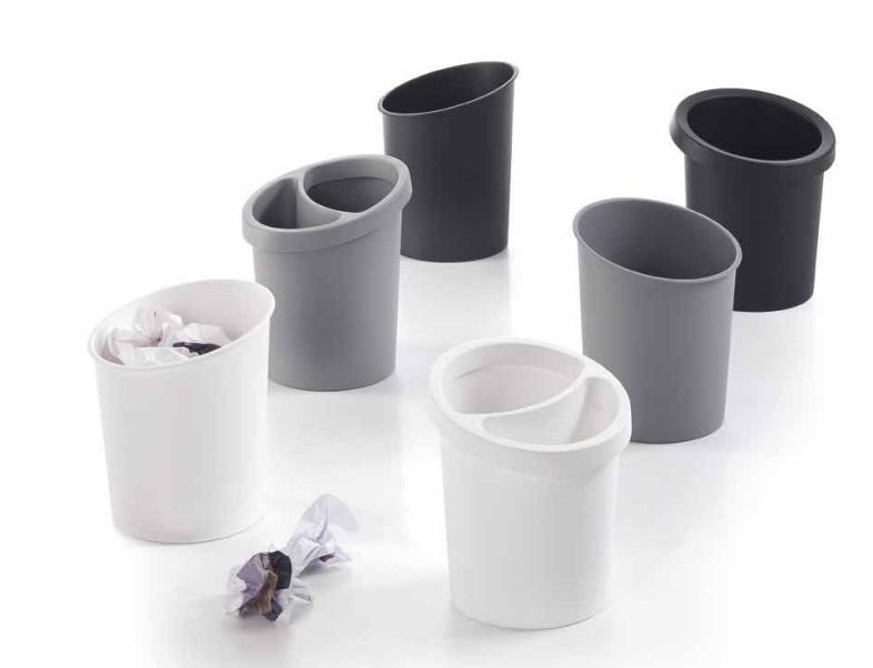 Sei organizer da scrivania in plastica, neri, grigi e bianchi, alcuni con divisorio, disposti su uno sfondo bianco con della carta.