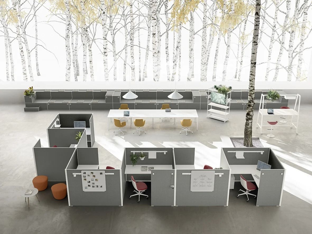 Un layout d'ufficio moderno con postazioni di lavoro grigie e un tavolo centrale, sullo sfondo di un murale raffigurante una foresta.