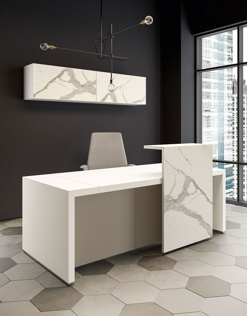 In un ufficio minimalista con pavimento in piastrelle esagonali e pareti scure, si trova una scrivania moderna con pannello frontale effetto marmo.