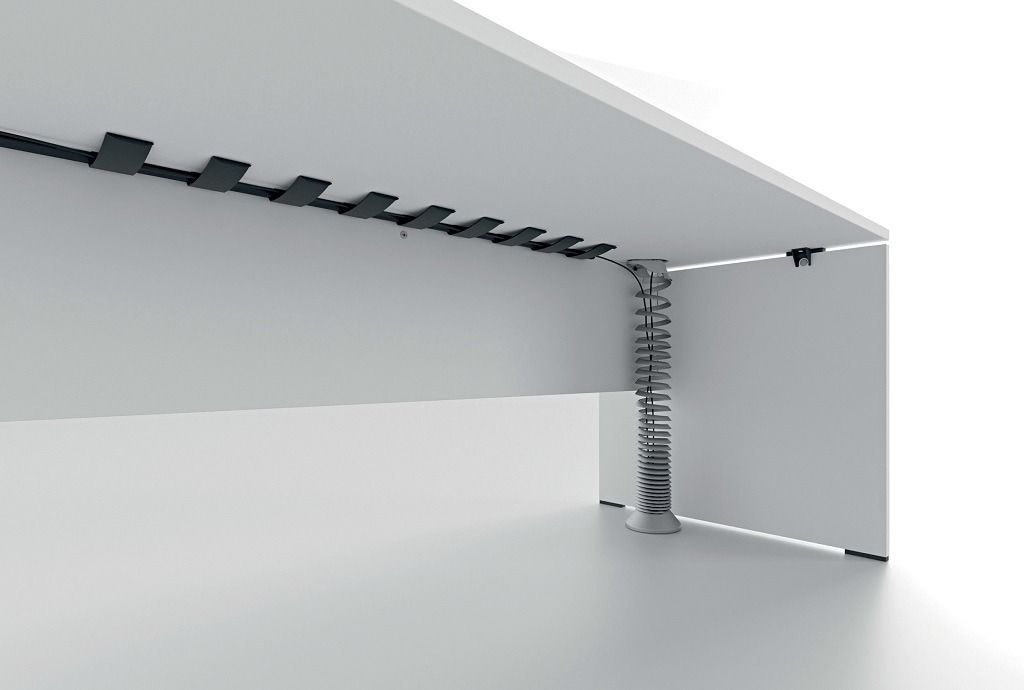 La parte inferiore della scrivania è bianca e presenta un vassoio orizzontale nero per la gestione dei cavi e una canalina flessibile verticale argentata per i cavi.