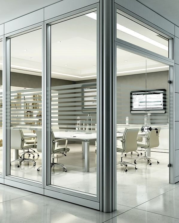 Una moderna sala conferenze con pareti in vetro, arredata con un tavolo bianco, sedie girevoli e uno schermo a parete.