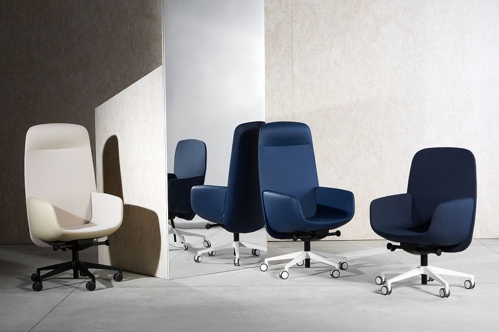 Quattro moderne sedie da ufficio con schienali di diverse altezze, nei colori blu e crema, disposte in un ambiente interno minimalista.