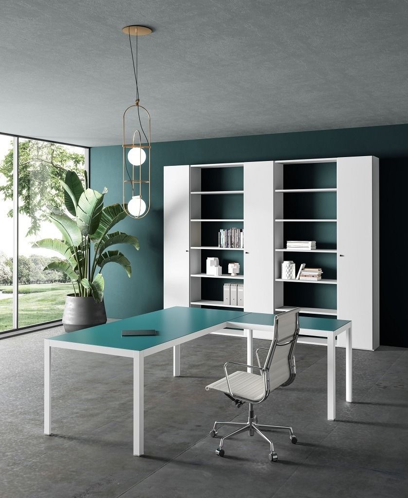 Un ufficio moderno con una scrivania a L color verde acqua, una sedia ergonomica bianca, due librerie bianche e una lampada a sospensione con paralume a globo.