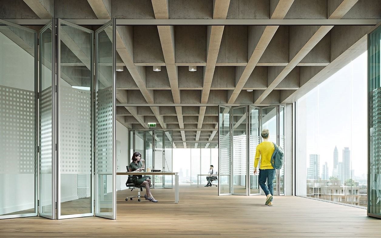 Persone in un ufficio moderno con soffitto a griglia, pavimento in legno e pareti di vetro a tutta altezza con vista sulla città.