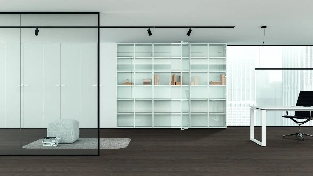 Un ufficio moderno e minimalista con una libreria bianca, una parete divisoria in vetro e una scrivania con sedia nera.