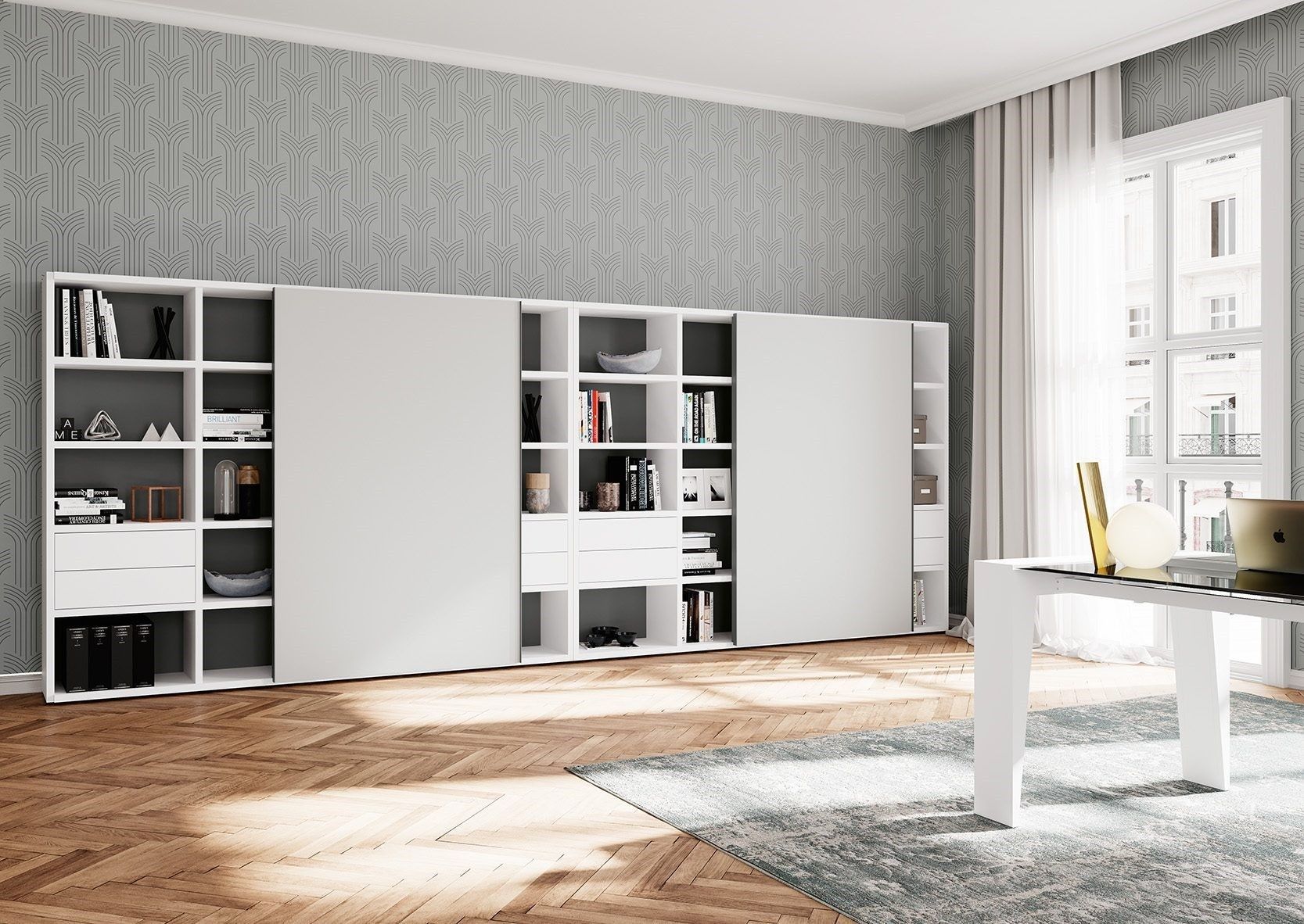 Una moderna libreria bianca con ante scorrevoli, su uno sfondo di carta da parati grigia a motivi geometrici, in una stanza luminosa con pavimento in legno.