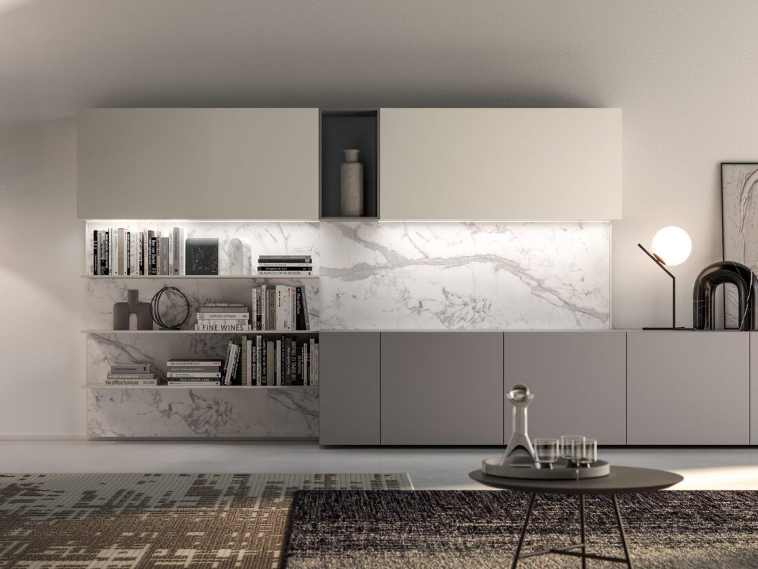 Un soggiorno minimalista con una libreria con schienale in marmo, eleganti mobili contenitori, un tavolino rotondo e un'illuminazione moderna.