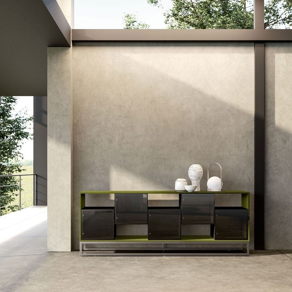 In una stanza luminosa e spaziosa, una moderna libreria color verde oliva con ante in vetro nero è addossata a una parete con finitura materica.