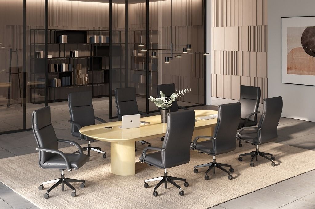 Una moderna sala conferenze con un tavolo ovale di colore chiaro circondato da otto sedie da ufficio in pelle nera, posizionate su un tappeto dalla texture particolare.