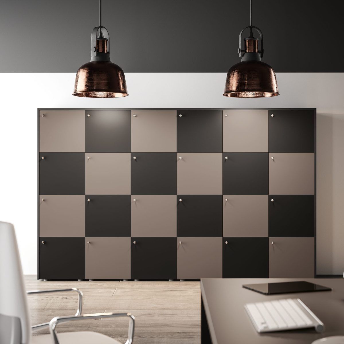 Una parete di un ufficio moderno presenta una griglia di armadietti alternati neri e beige, illuminati da due lampade a sospensione in rame.