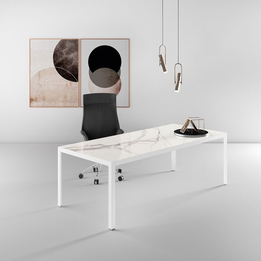 Un ufficio minimalista con scrivania con piano in marmo bianco, sedia ergonomica nera, due stampe artistiche astratte e lampade a sospensione.
