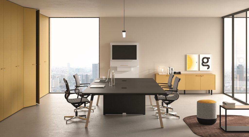 Sala riunioni moderna con tavolo centrale scuro, sedie, armadio contenitore giallo, schermo a parete e vista sulla città.