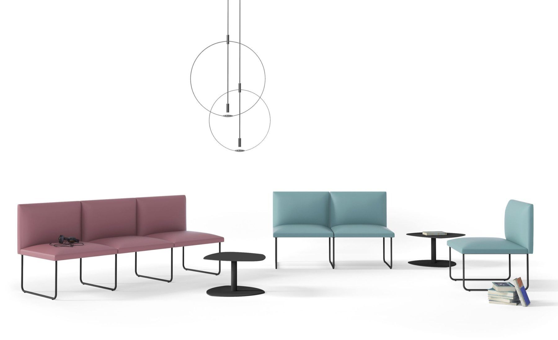 Una sala relax in stile minimalista con panche modulari color malva e azzurro, tavolini rotondi e sottili lampade a sospensione.