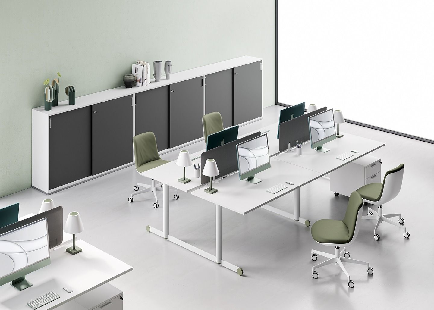 Spazio ufficio moderno caratterizzato da file di scrivanie bianche con computer e sedie, addossate a un lungo mobile contenitore grigio.