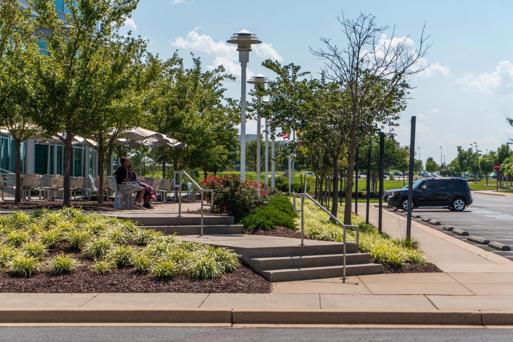 Outdoor seating area surrounded by commercial landscaping and plants at a business property