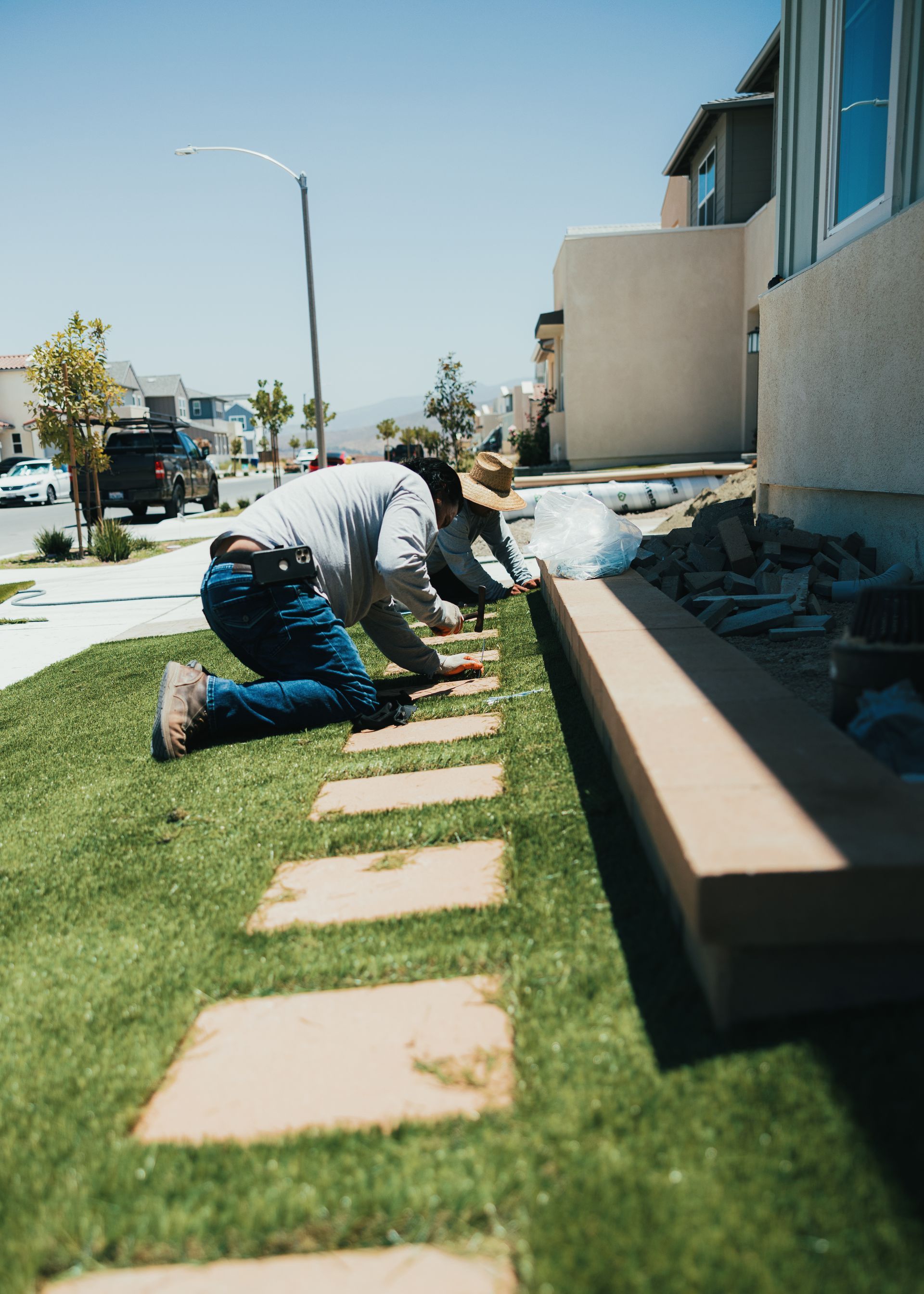 San Diego landscapers installing artificial turf in a residential backyard.
