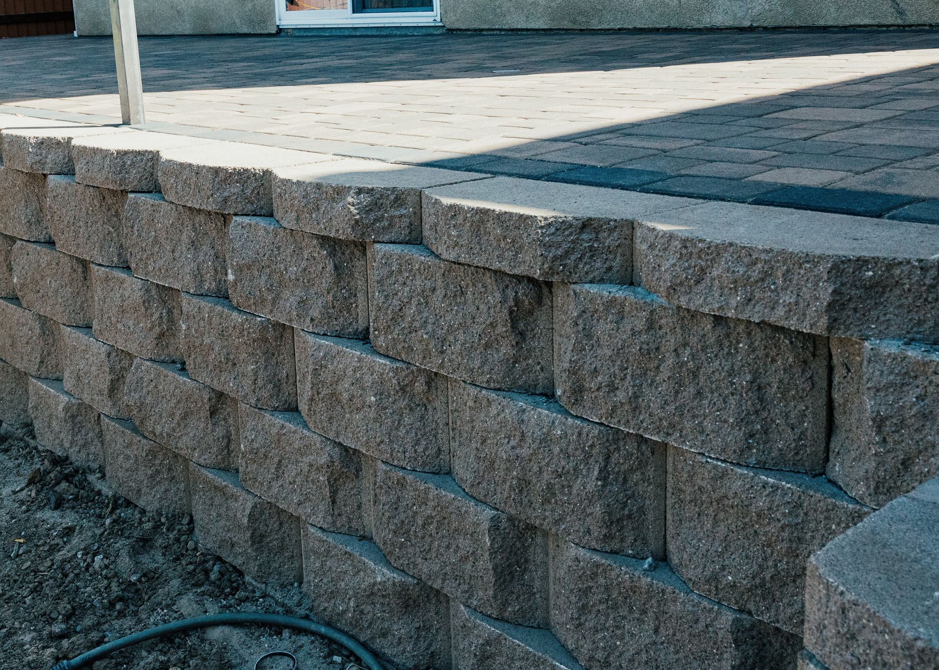 Custom pavers retaining wall built by San Diego landscape contractors for slope support