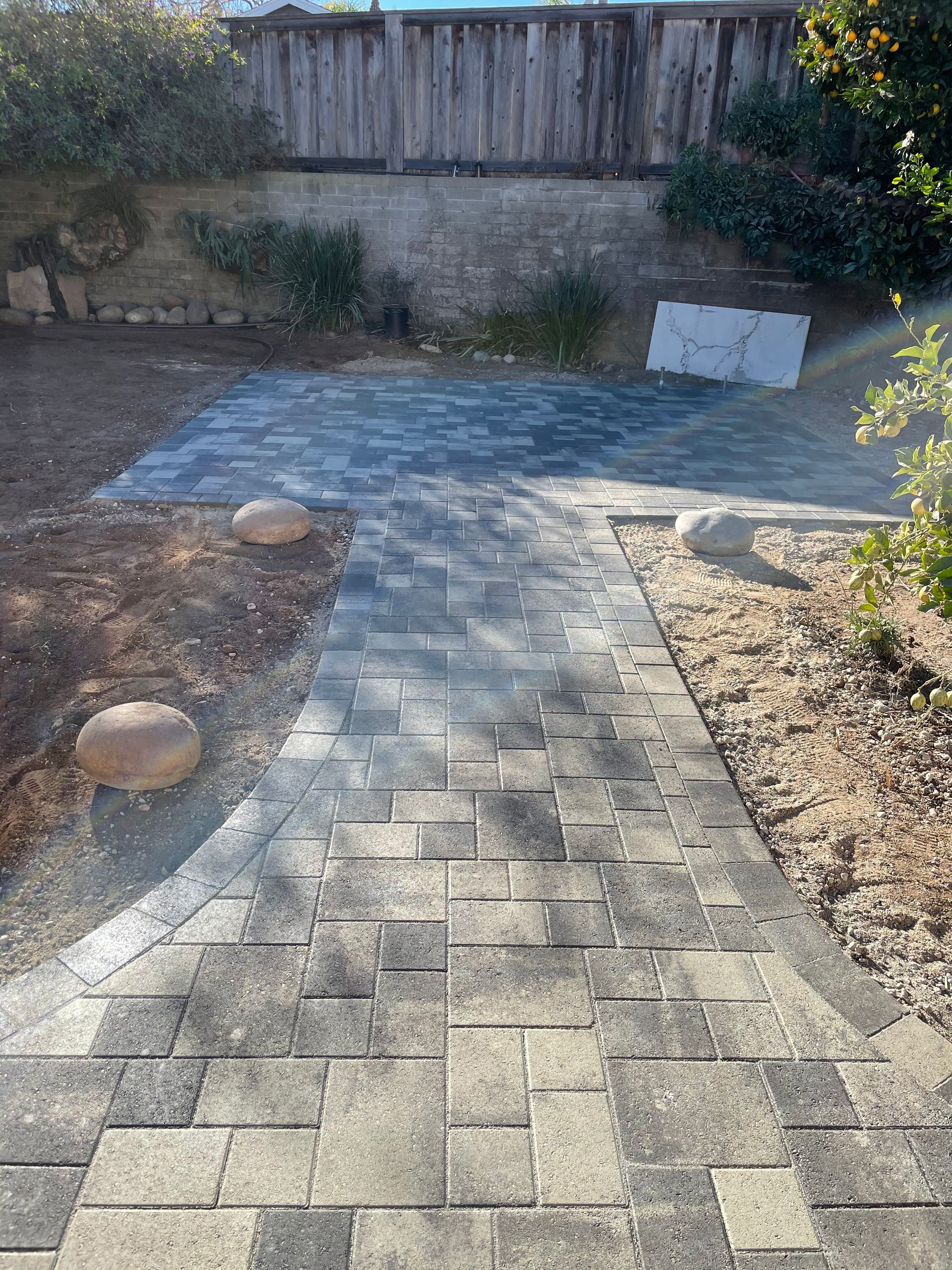 Paver walkway leading to patio in a small San Diego backyard design