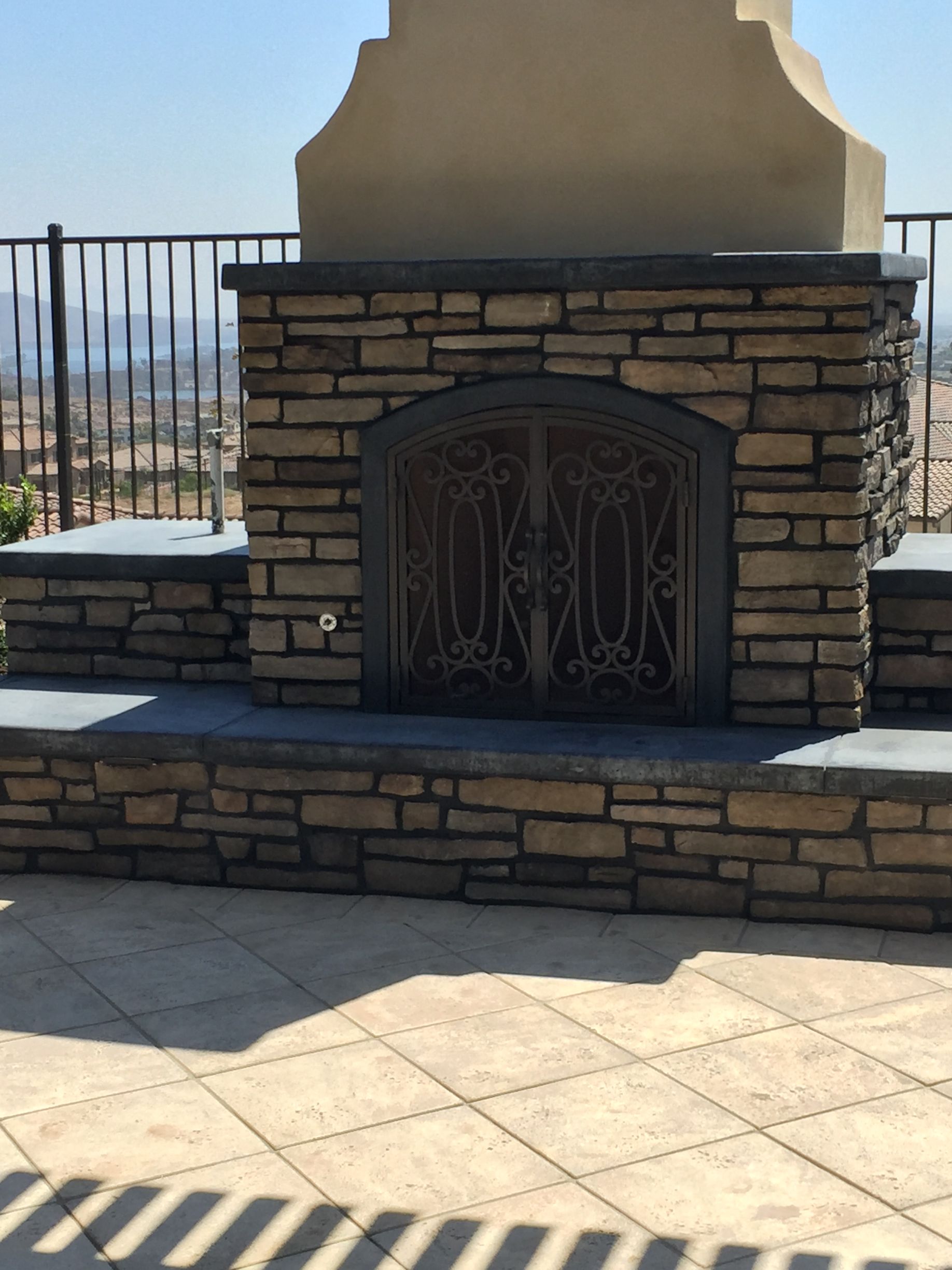 Outdoor patio with built-in fireplace as part of backyard landscape design in San Diego
