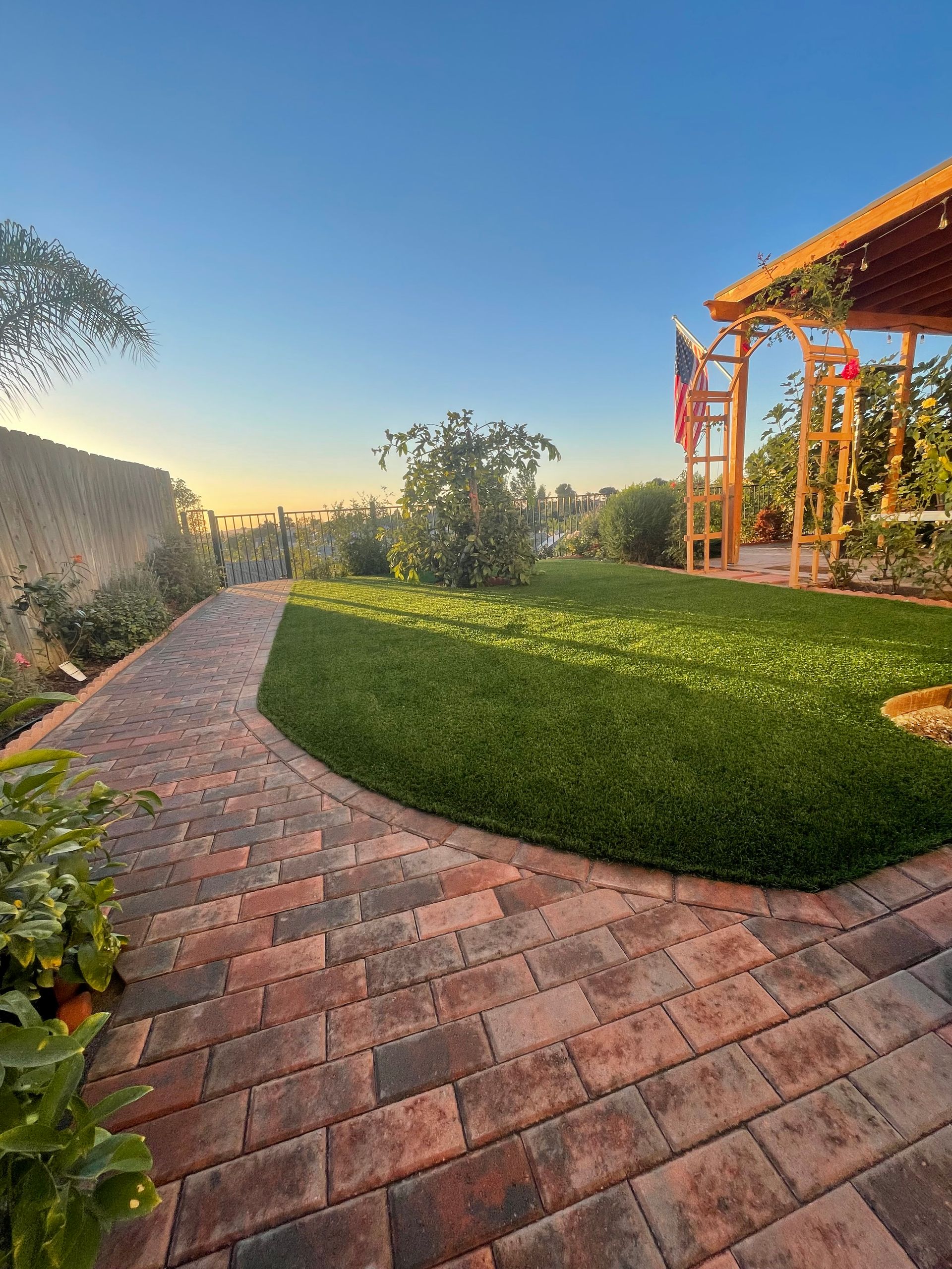 Artificial turf and paver patio combination in a San Diego family backyard.