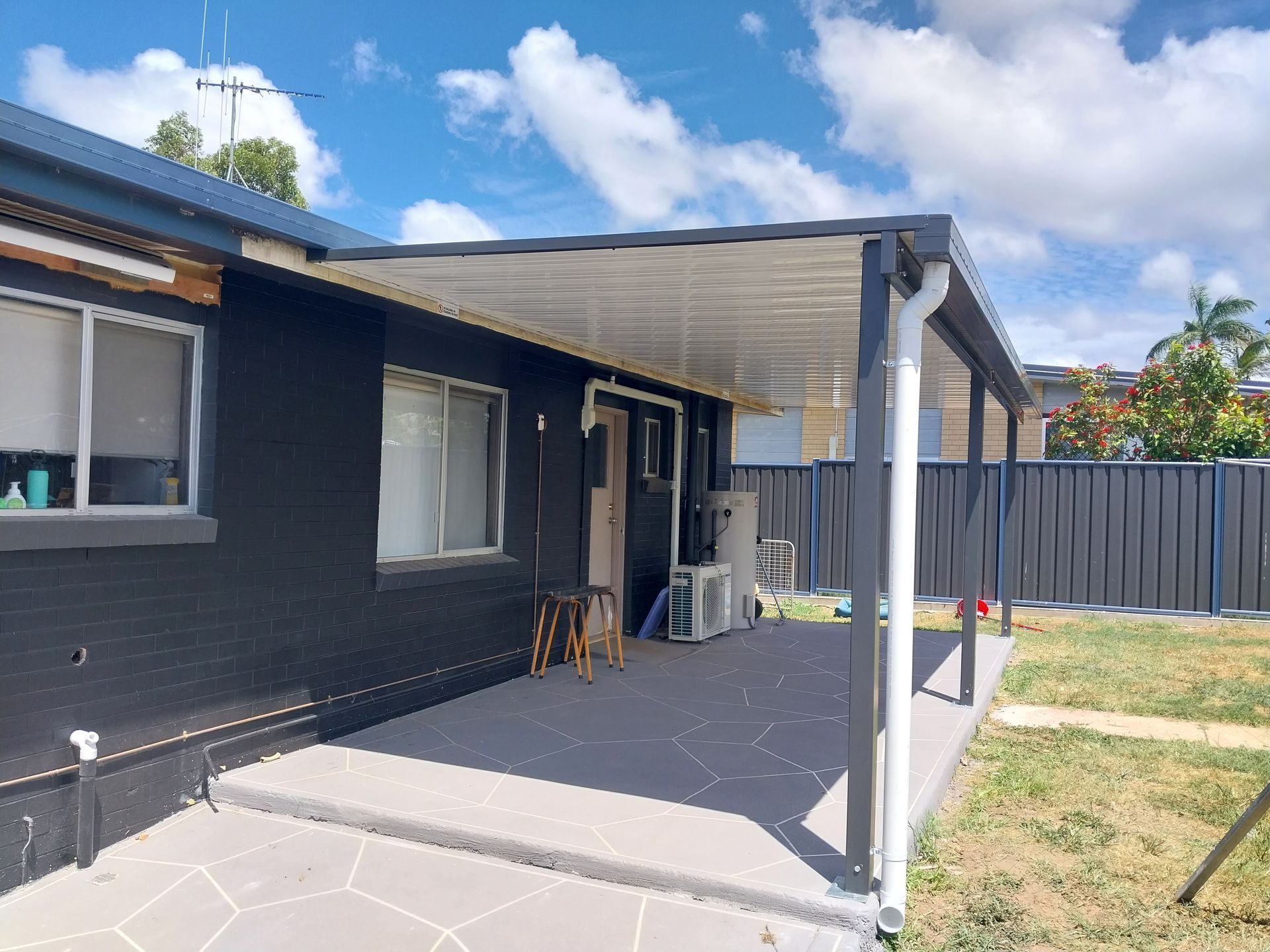 Cozy Verandah with Deckchair with Pink Flowers on Reflective Table — Bundy Tiny Homes and Carports in Branyan, QLD