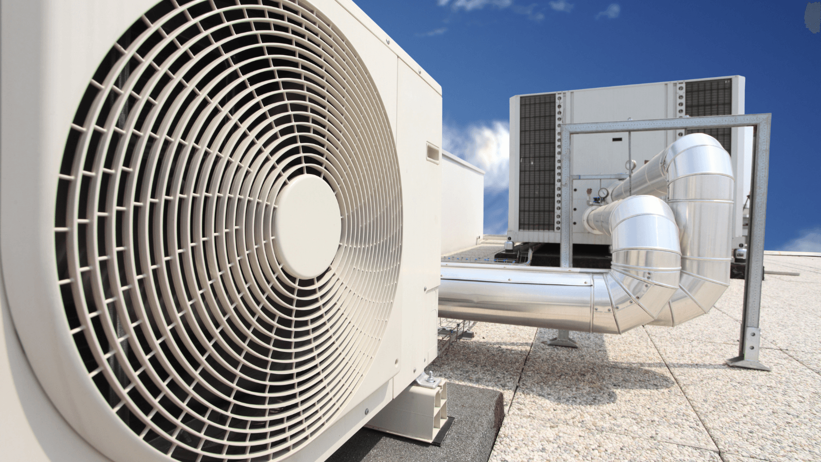 A white air conditioner is sitting on top of a building.