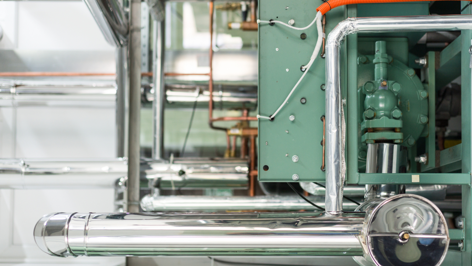 A close up of a machine with pipes and valves in a factory.