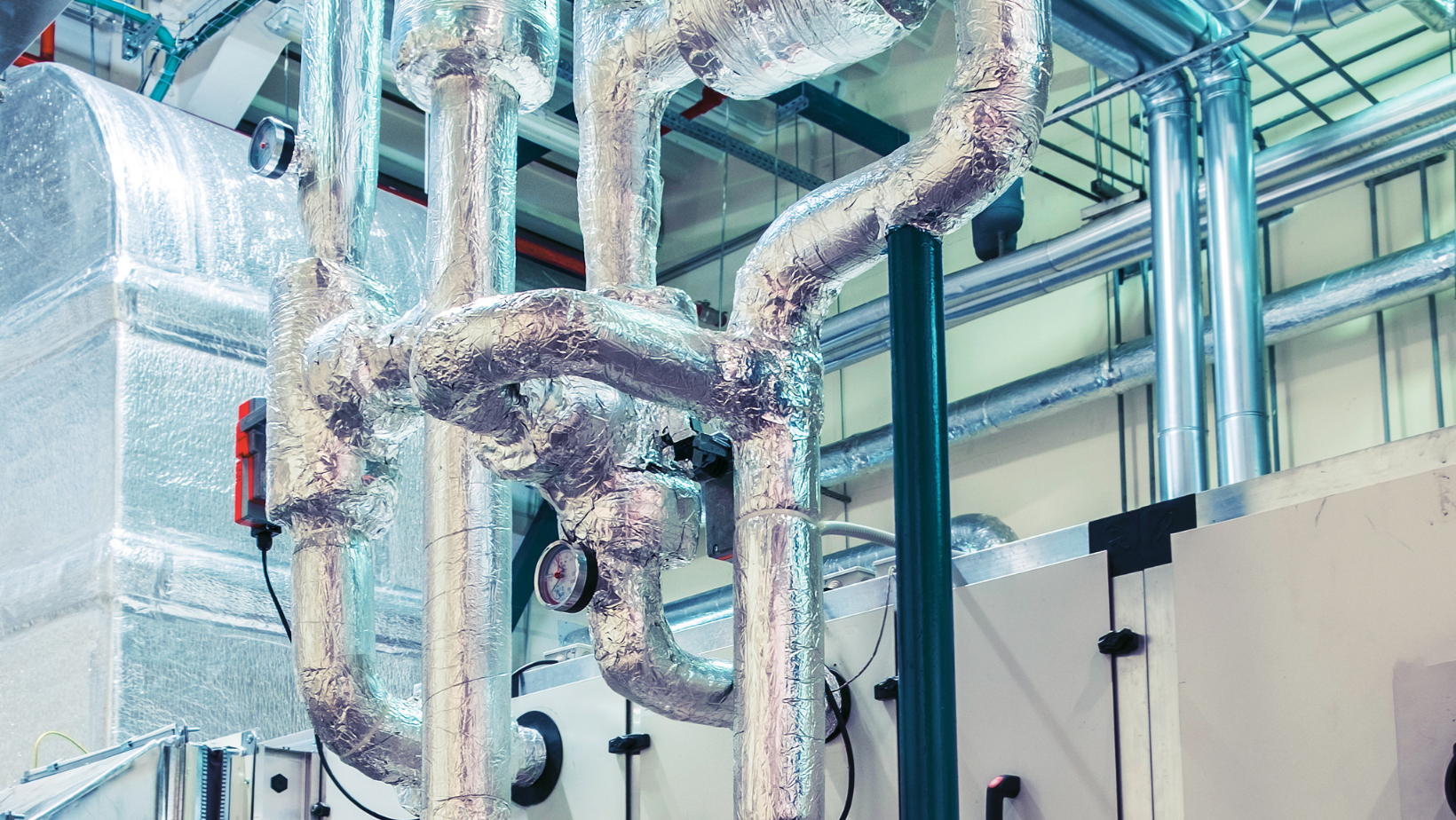 A bunch of pipes are hanging from the ceiling of a building.