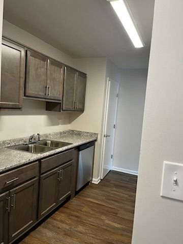 Kitchen with gray cabinets, stainless steel appliances, and dark wood floors.