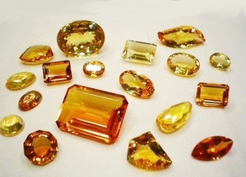 Una varietà di pietre gialle e arancioni su una superficie bianca