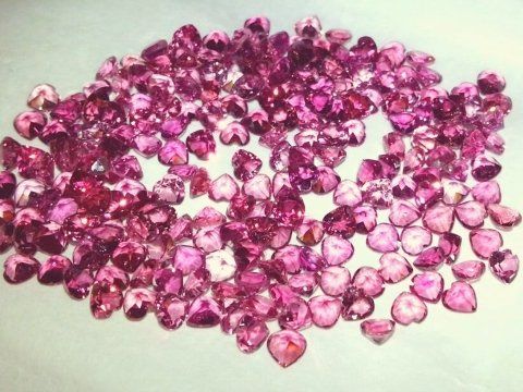 Un mucchio di pietre rosa su una superficie bianca.