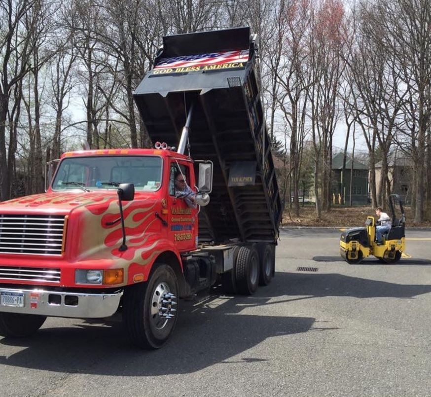 A red dump truck is parked on the side of the road