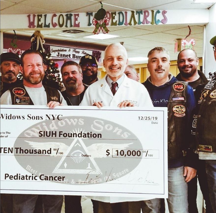 A group of men holding a large check for the siuh foundation