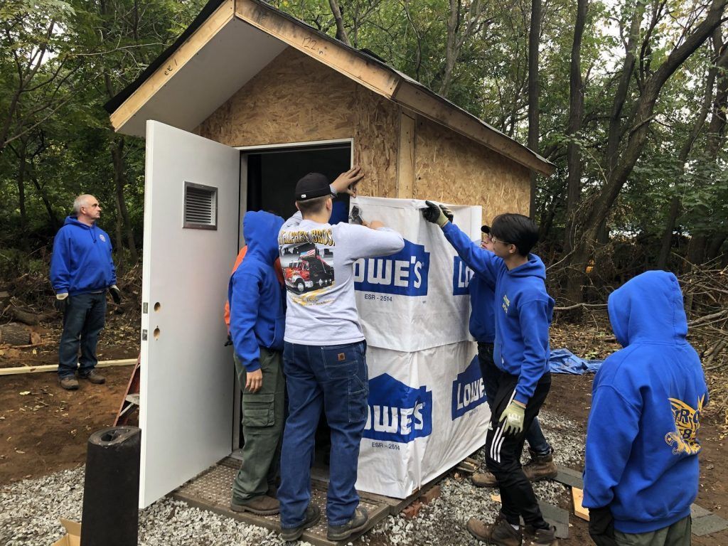 A group of people are working on a shed.