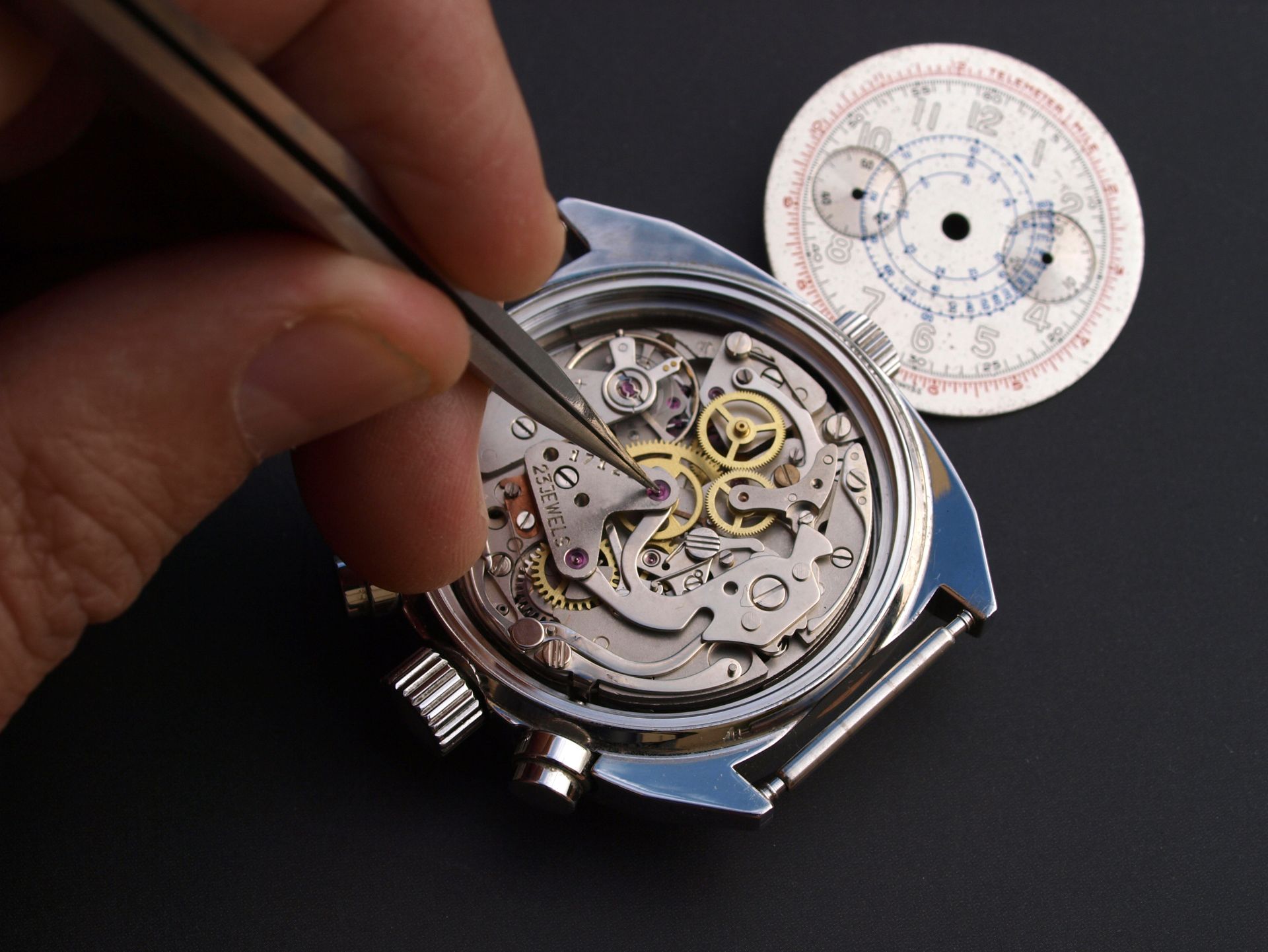 Una persona sta lavorando su un orologio con un paio di pinzette