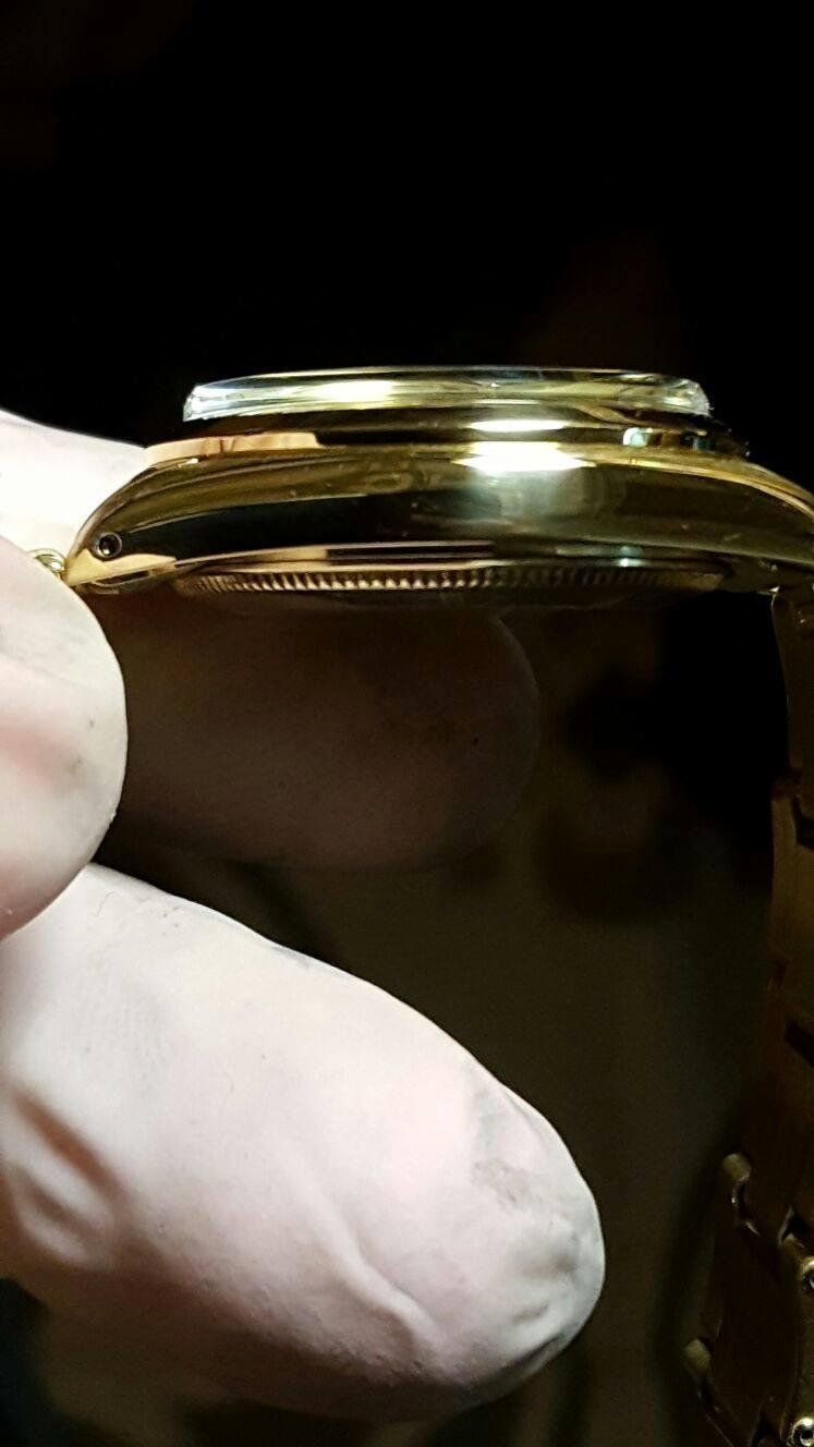 Una persona tiene in mano un orologio d'oro.