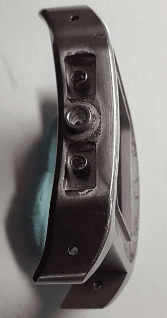 Un primo piano di un oggetto metallico su una superficie bianca.