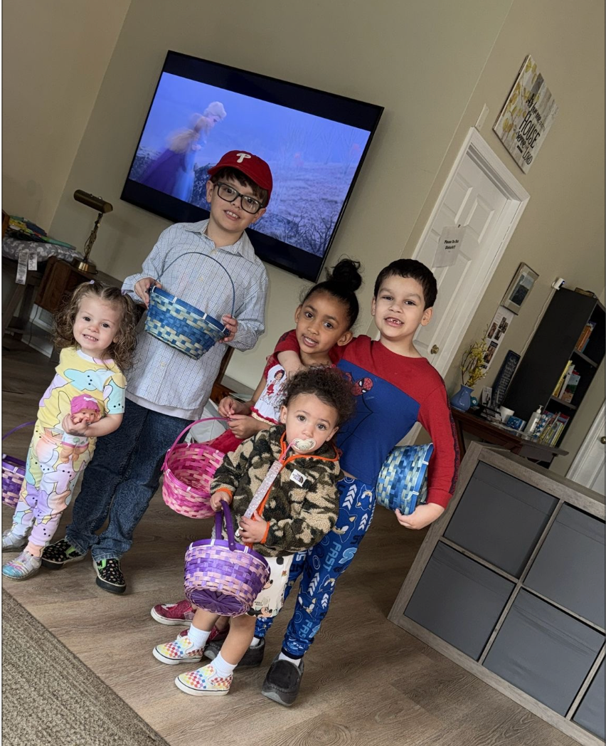 Five children with Easter baskets posing indoors.