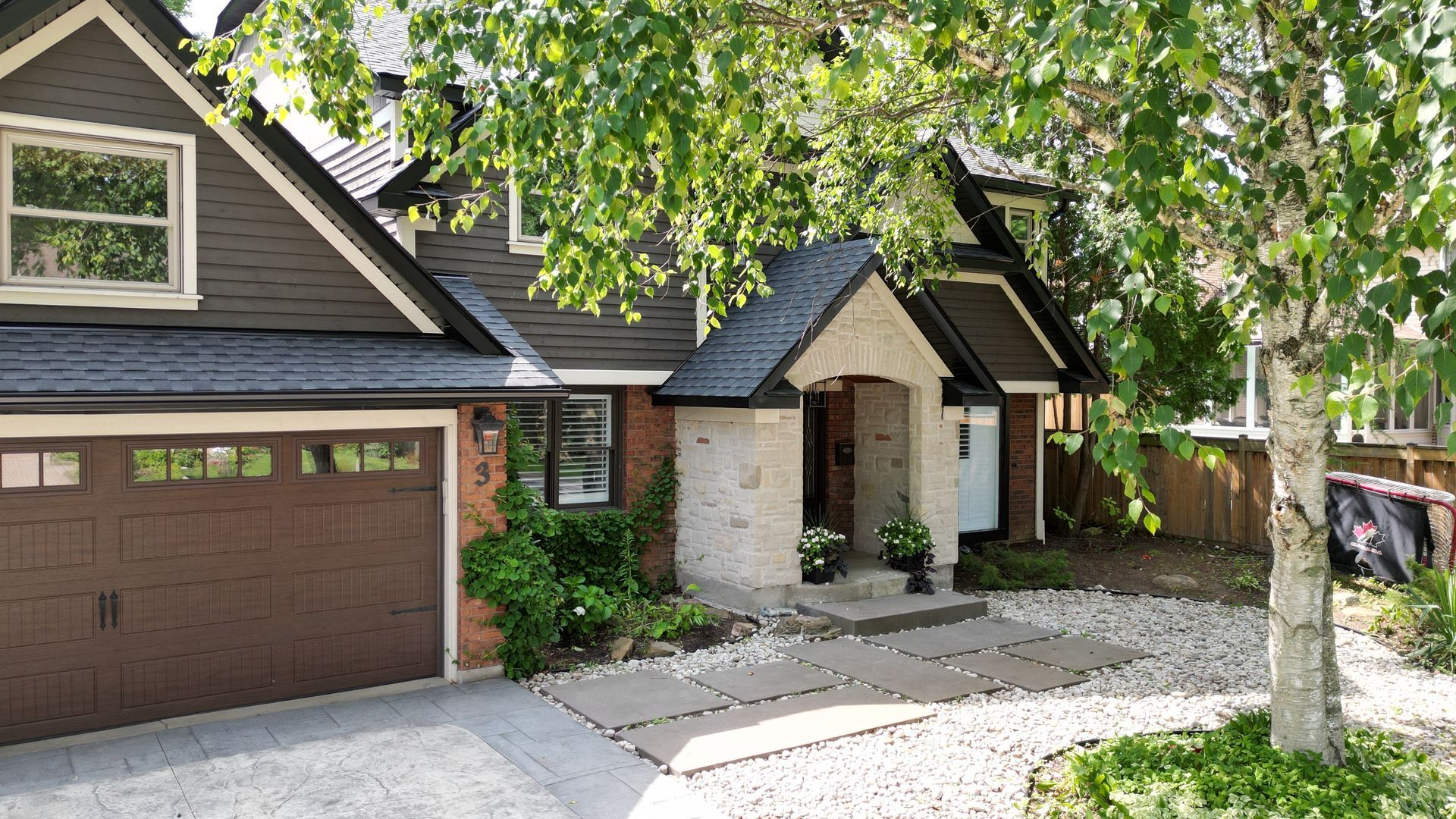 The front of a house with a brown garage door
