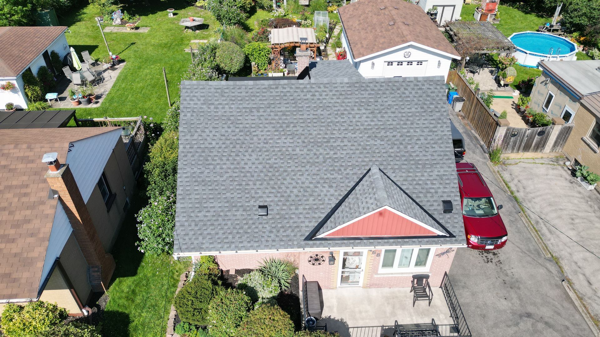 An aerial view of a house with a red van parked in front of it