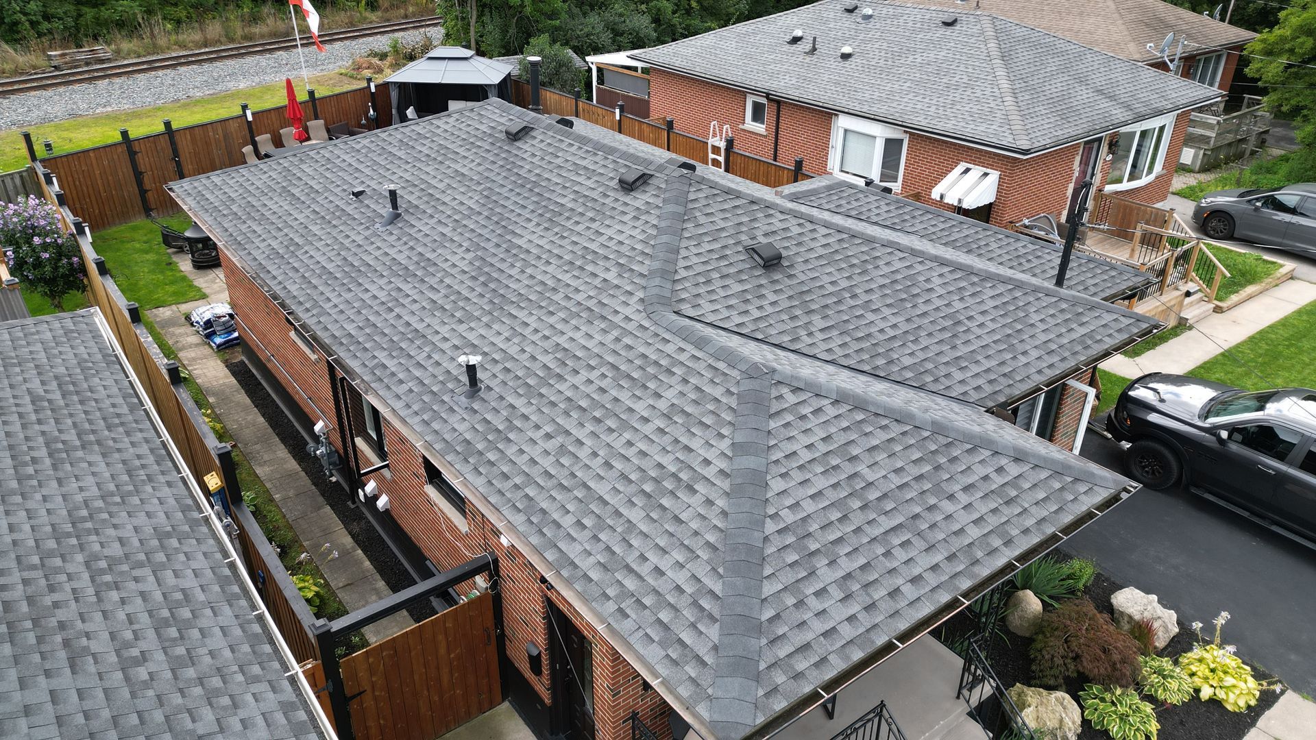 An aerial view of a roof of a house with a car parked in front of it.