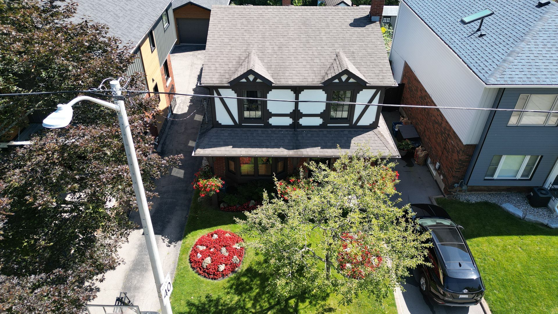 An aerial view of a house with a van parked in front of it