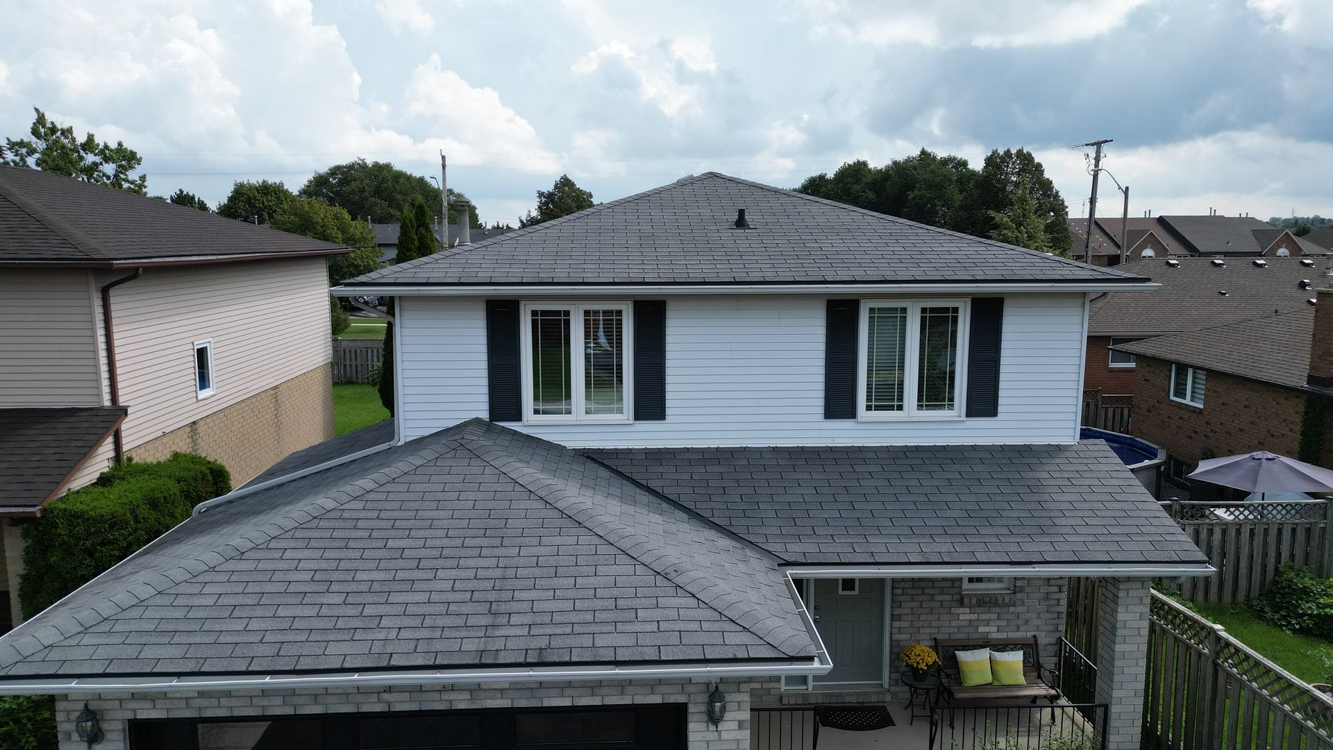A white house with a gray roof and black shutters
