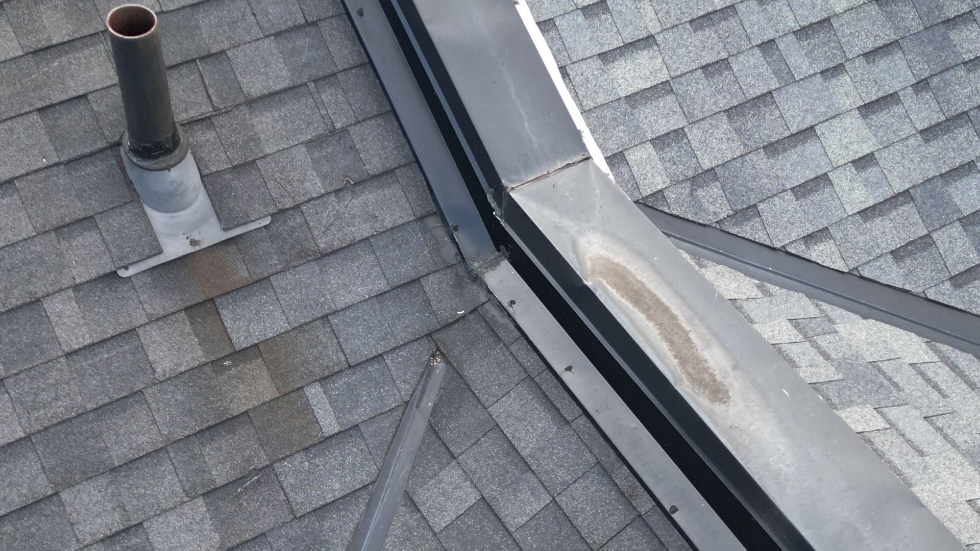 A close up of a roof with a chimney on top of it.