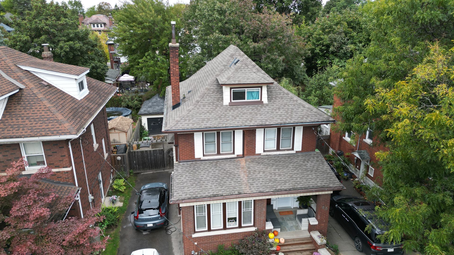 An aerial view of a house with a car parked in front of it