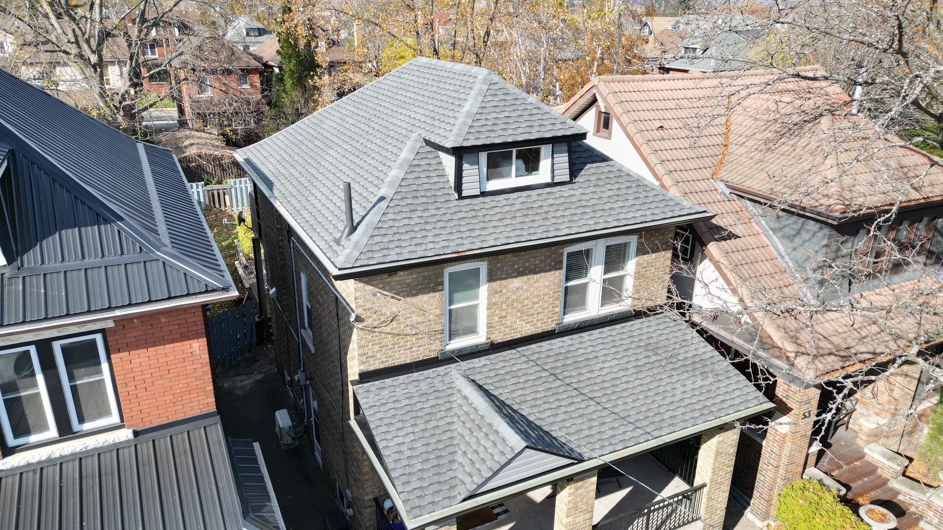 An aerial view of a house with a gray roof