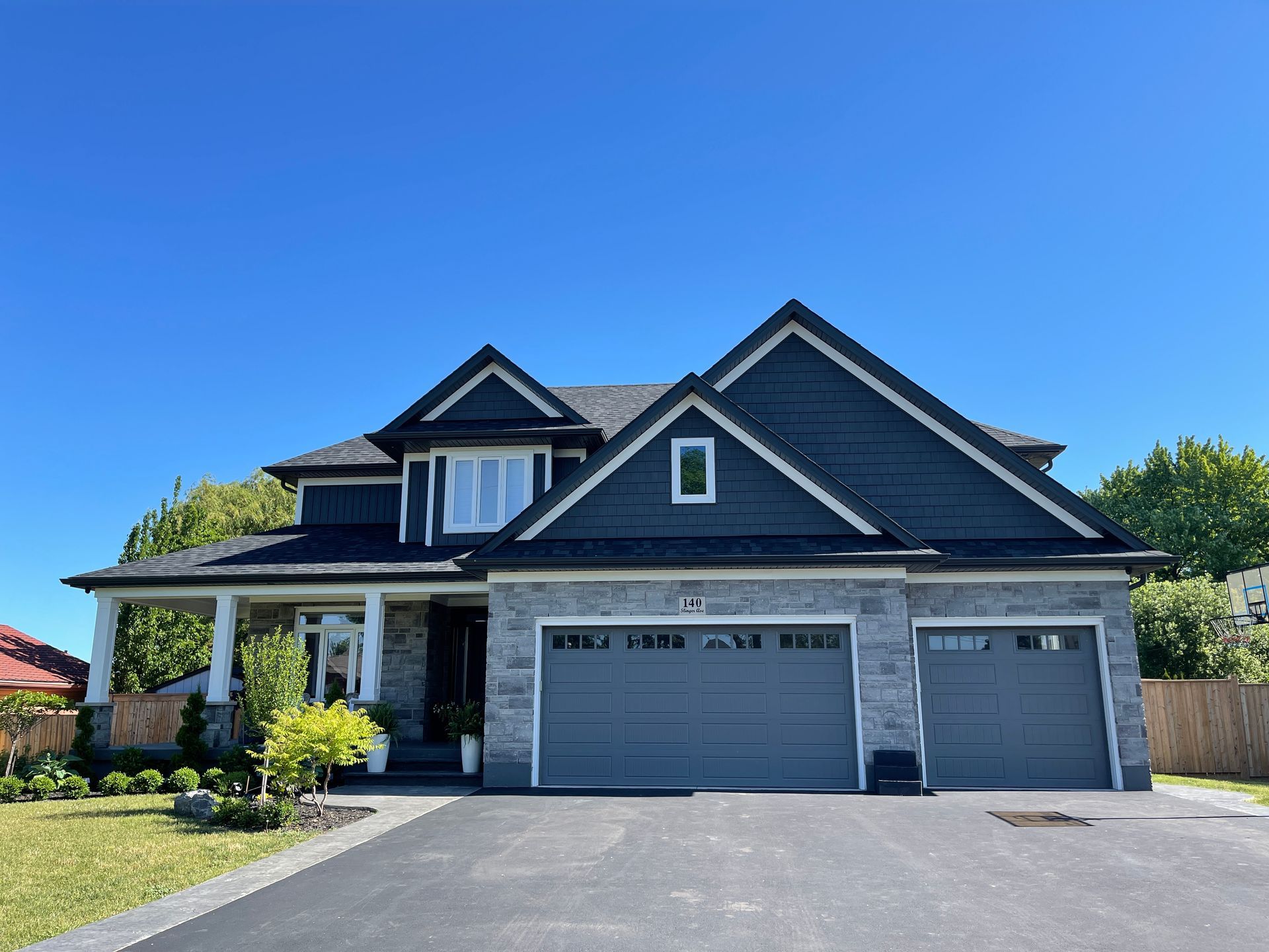 A large house with two garage doors and a blue sky in the background