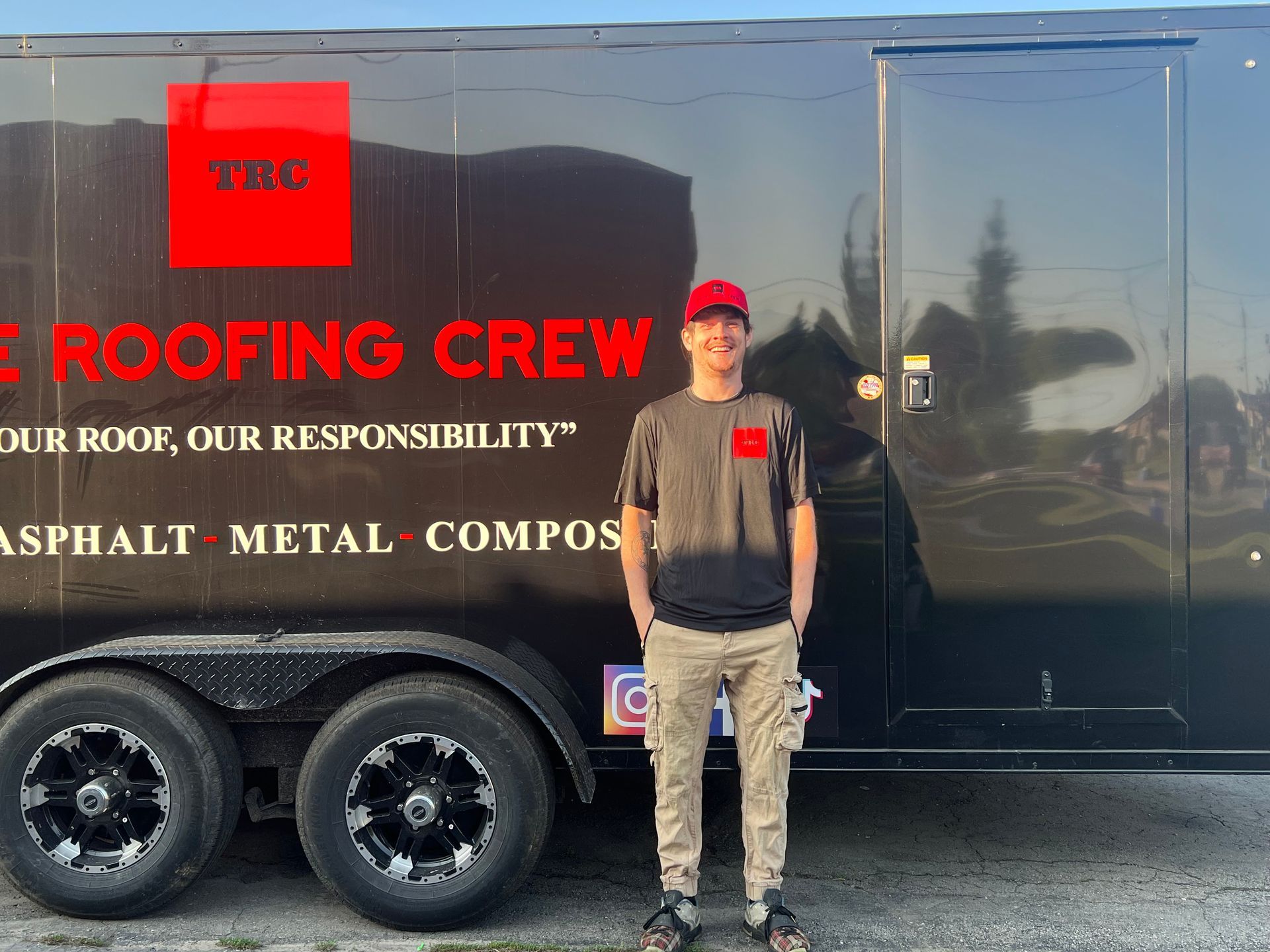 A man standing in front of a trailer that says roofing crew